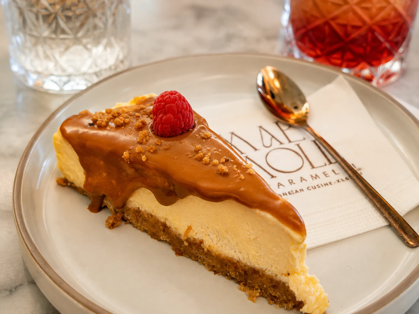 Biscoff cake served at Karamelli with caramel topping and raspberry