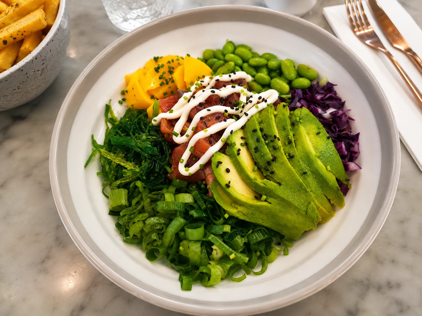 Salmon poke bowl with avocado, mango, edamame, wakame, cabbage and sesame